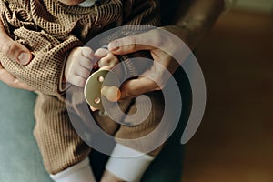 Baby holds a pacifier in his mother arms