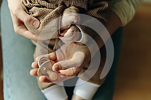 Baby holds a pacifier in his mother arms