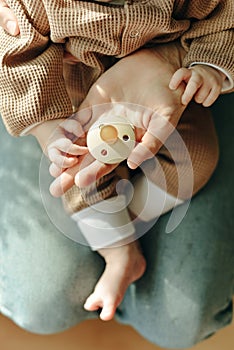 Baby holds a pacifier in his mother arms