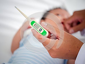Baby illness medicine flu fever and thermometer, a doctor checks the temperature of the ill baby. Digital thermometer to measure
