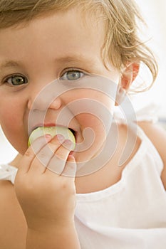 Baby indoors eating apple