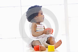 Baby indoors playing with cup toys photo