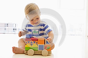 Baby indoors playing with truck