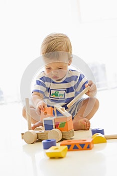 Baby indoors playing with truck