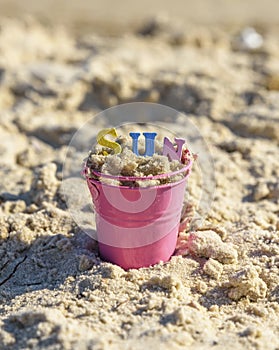 Baby iron bucket filled with wooden colorful letters, inscripti