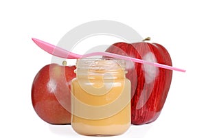 Baby jar with apple sauce and pink spoon