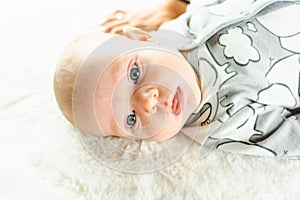 Baby kid cute child banner. Happy cute baby infant girl lying on white bed background. Light background. Little child