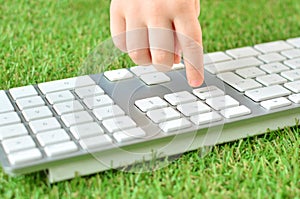 Baby kid finger on a computer keyboard button.