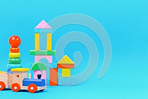 Baby kid toy background with colorful wooden toys on light blue background