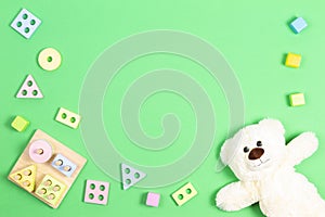 Baby kid toys background. Teddy bear and wooden pastel color geometry educational toy for children on light green