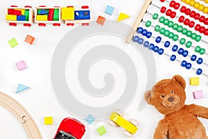 Baby kids toys background with teddy bear, toy tools, wooden train, cars and colorful blocks. Top view, flat lay