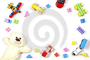 Baby kids toys frame with teddy bear, airplane, train and wooden and plastic toys on white background. Top view