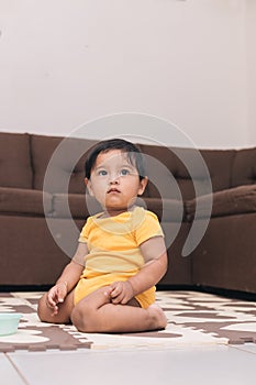 baby kneeling in the living room of the house watching