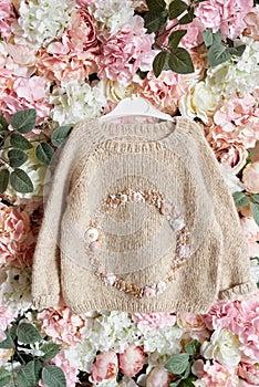 Baby knitted clothes. Handmade knitted sweater with flowers. Jacket with embroidery