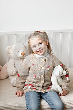 Baby knitted clothes. Handmade knitted sweater with fly agaric mushrooms. Jacket with embroidery. Child girl at home