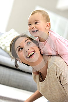 Baby laughing on her mother's back