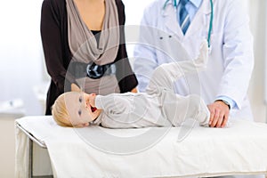 Baby laying on table at pediatricians cabinet