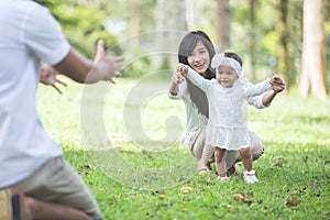 Baby learn to walk with their parent in the park