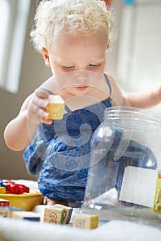 Baby, learning and kid play with blocks in home, growth and creative childhood development in kindergarten. Child