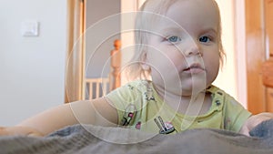 The baby learns to walk for up to a year, holds on to the bed. Rejoices in his every move