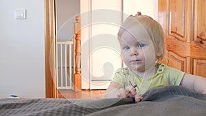 The baby learns to walk for up to a year, holds on to the bed. Rejoices in his every move