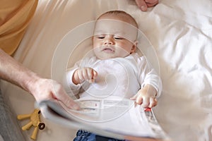 The baby lie leisurely and lull with parents in the living room at house.