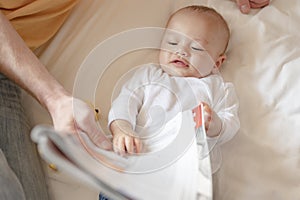 The baby lie leisurely and lull with parents in the living room at house.