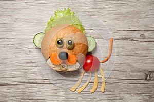 Baby lion made of bread and vegetables on wood