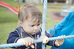 Baby looking at blue ropes