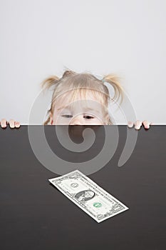 Baby looking at dollar banknote vertical