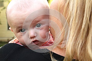 Baby looks over his mother`s shoulder.