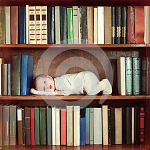 Baby lying on book shelf in bookcase