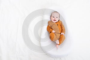 The baby is lying in a cocoon of copy space . The baby is 0-3 months old. A contented infant. An article about choosing