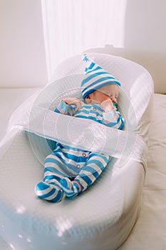 The baby is lying in a cocoon of copy space . The baby is 0-3 months old. A contented infant. An article about choosing