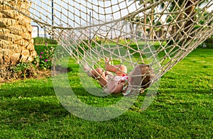 Baby is lying on a hammock. Selective focus.