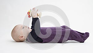 Baby lying on his back with toy