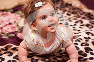 Baby lying on a rug.