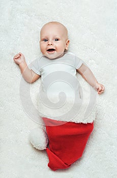 Baby is lying in the Santa's hat