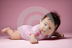 Baby lying on stomach looking at viewer. photo