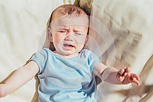 Baby lying in the sun angry and crying calling his parents