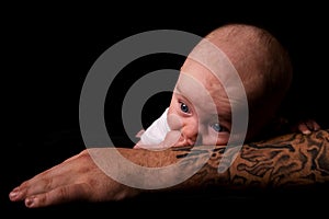 Baby Lying on Tattooed Arm