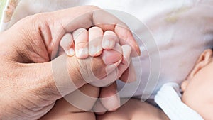 Baby and mamy hold his hand with love