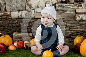 Baby with many different pumpkins