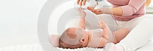 Baby massage banner with copy space. Kids therapist applying massage oil to baby boy. Mother massaging her newborn baby.