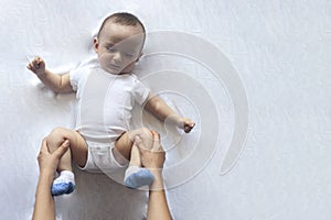 Baby massage. Mom doing gymnastics with kid