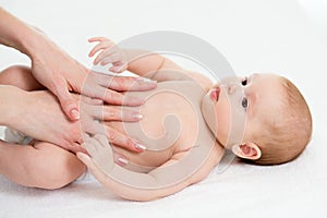Baby massage. Mom massaging child belly. Treatment of colic