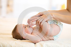 Baby massage. Mother doing gymnastics kid.