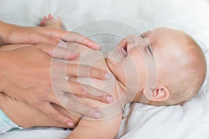 Baby massage. Mother massaging infant belly