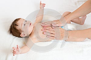 Baby massage. Mother massaging infant belly