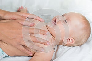 Baby massage. Mother massaging infant belly photo